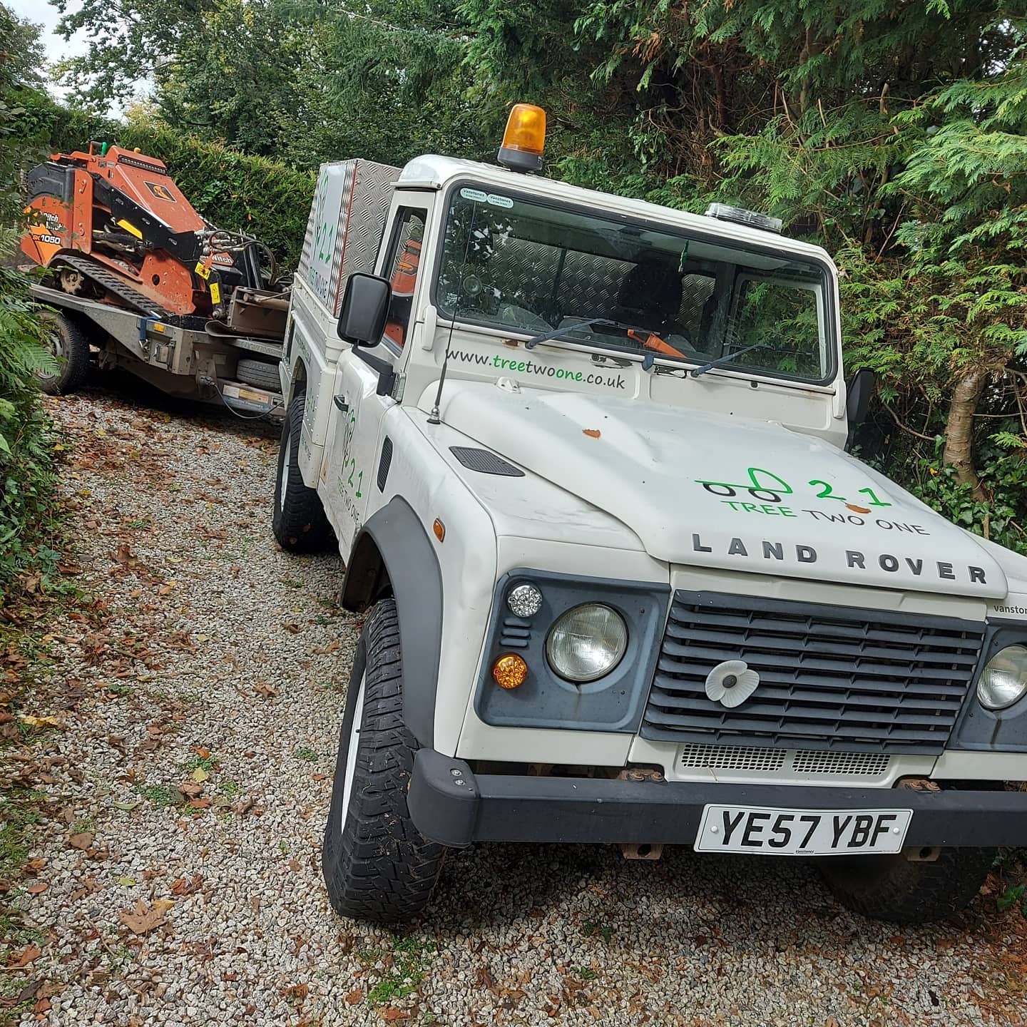 The Tree Two One Land Rover towing the tracked loader on a trailer
