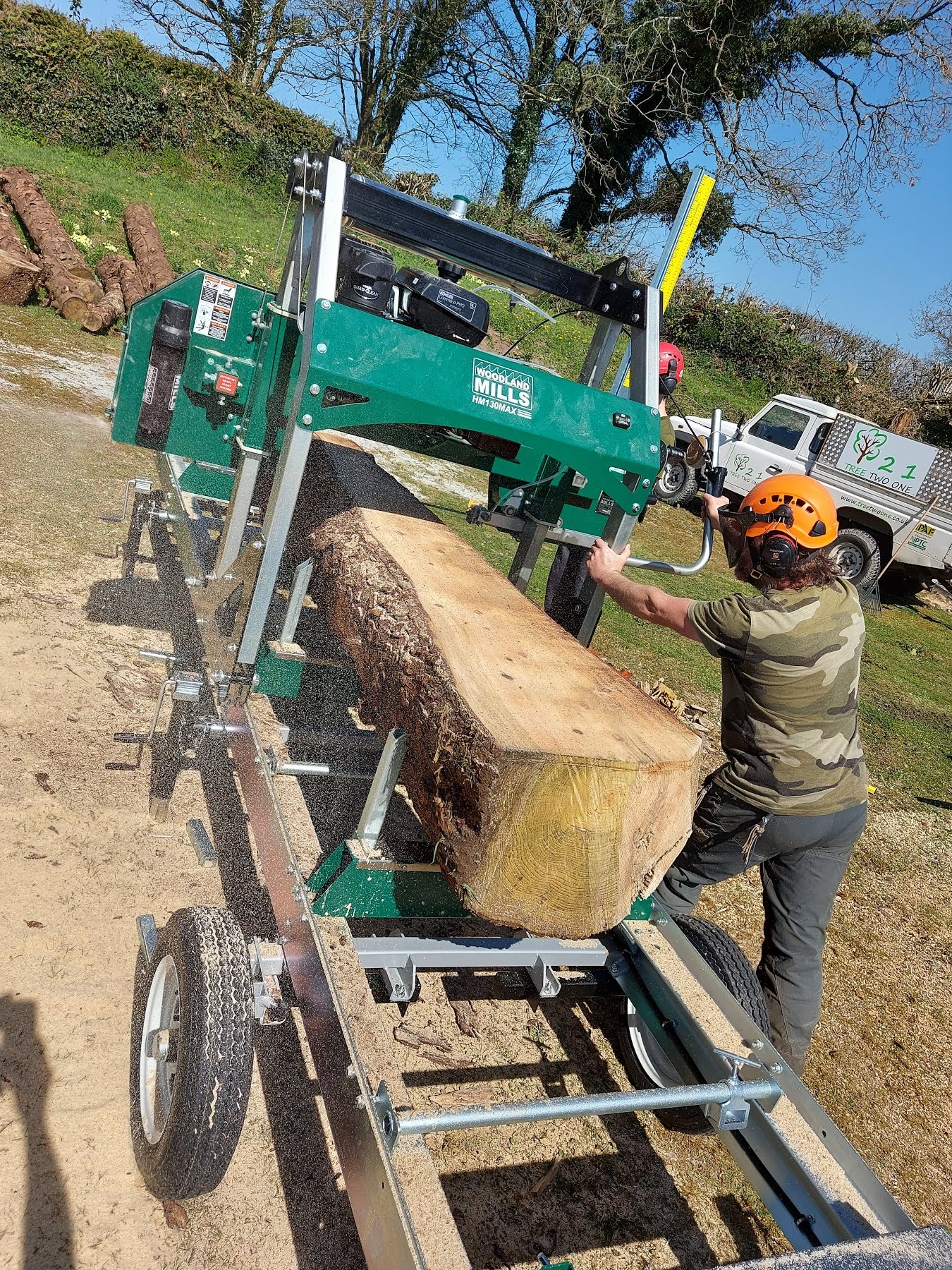 A mobile saw mill cutting a large trunk into timber
